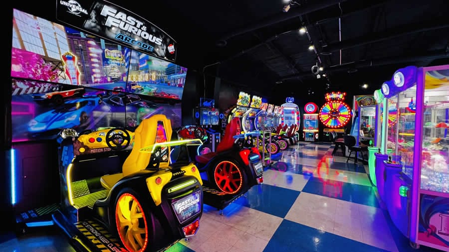 Wide view of arcade with racing games and other games further back